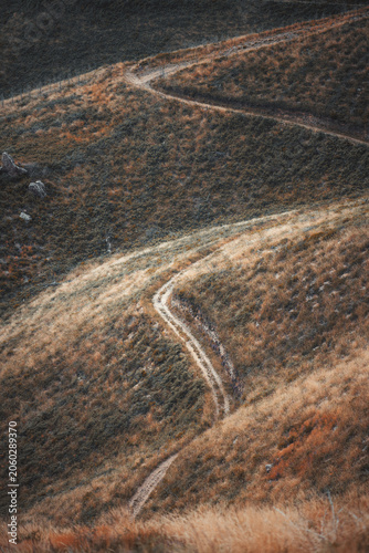 Canvas Print Telephoto view of a winding Camino de Santiago dirt path crossing dry grass hill