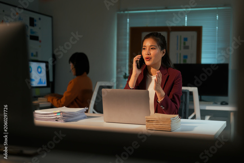 Business woman talking on phone working late at night