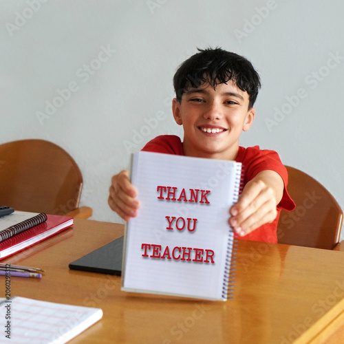 thank you teacher. words written in the notebook that a child shows happily to the camera