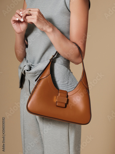 a woman with a luxury handbag slung over her arm