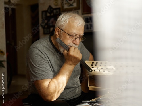 Tableau sur toile Man playing harmonica indoors, creating soulful melodies during a tranquil after
