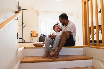 Happy father and son bonding on home wooden steps