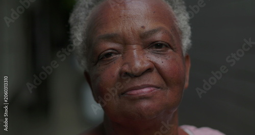 African American elderly woman outdoors close up looking at camera with calm reflective expression conveying dignity resilience life experience wisdom and quiet inner strength