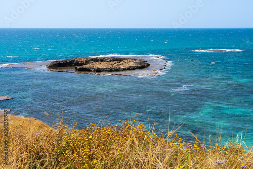Picturesque Mediterranean coastline with turquoise waters, unique kurkar rock formations, panoramic seascapes, and rich marine biodiversity, known for its natural beauty and relaxing atmosphere.