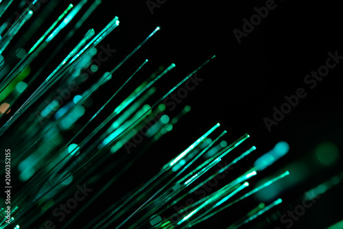 Foto Vibrant green fiber optic strands stretch diagonally across pitch black background with nice bokeh