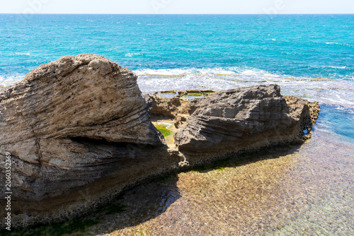 Picturesque Mediterranean coastline with turquoise waters, unique kurkar rock formations, panoramic seascapes, and rich marine biodiversity, known for its natural beauty and relaxing atmosphere.
