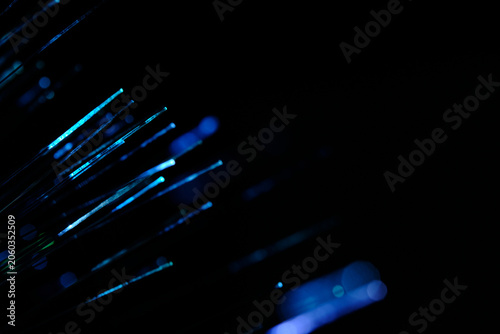 Diagonal blue and cyan glowing fiber optic strands extending out into deep dark space behind.