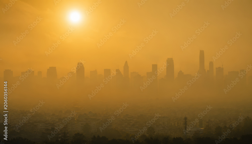 Obraz premium City skyline at sunset with hazy atmosphere and sunlight