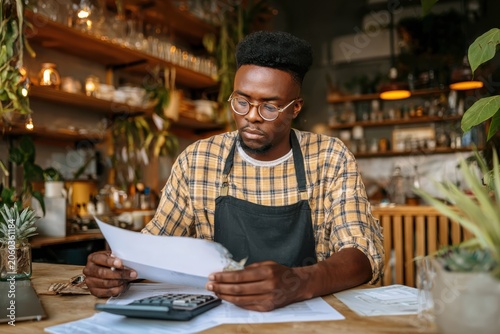 Black male coffee shop owner managing business finances