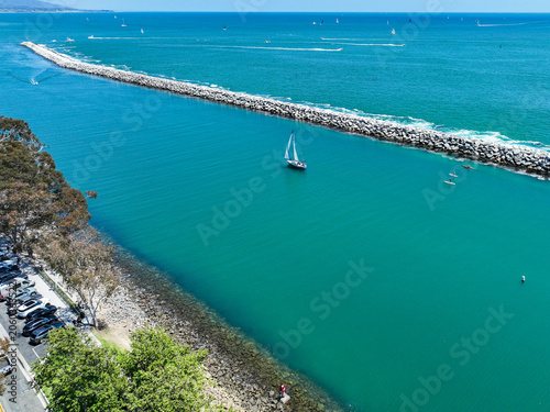 The Dana Point California  Harbor from above the Richard Henry Dana Statue using a UAV Drone looking at the harbor and the breakwaters protecting the harbor and the inlet from Pacific Oacea Waves