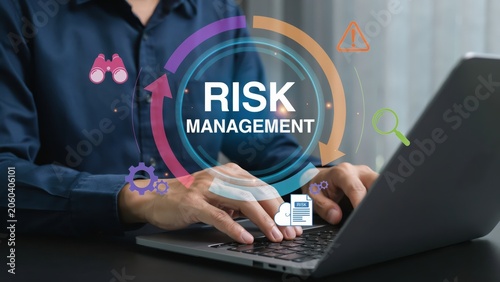 Business person typing on a laptop with a digital risk management icon overlay