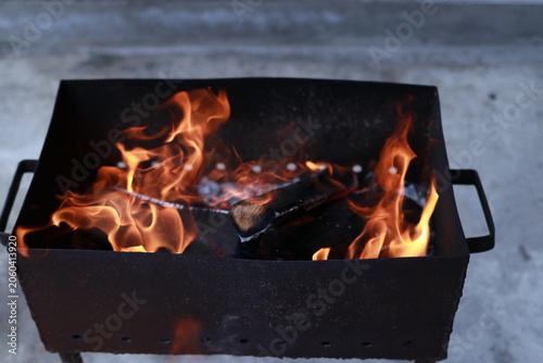 Bright flames burning inside a metal barbecue grill outdoors