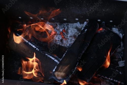 Open fire and burning wood in an outdoor charcoal brazier