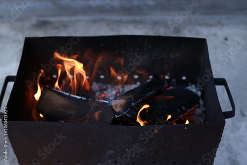 Flames rising from charcoal grill before barbecue cooking