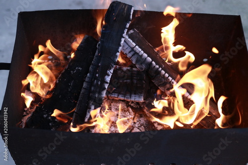 Hot firewood flames and charcoal embers for barbecue cooking