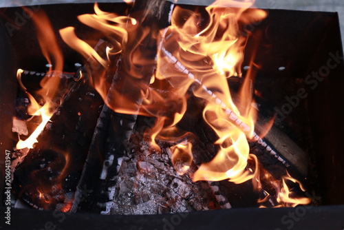 Flames rising from charcoal grill before barbecue cooking