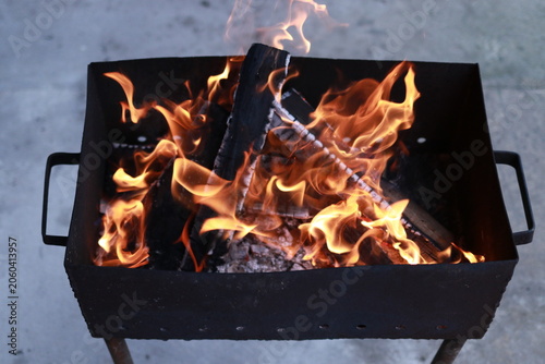 Flames rising from charcoal grill before barbecue cooking