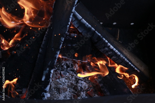 Outdoor metal brazier with open flame and burning firewood