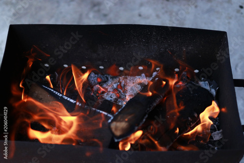 Barbecue fire with charred wood and orange flames