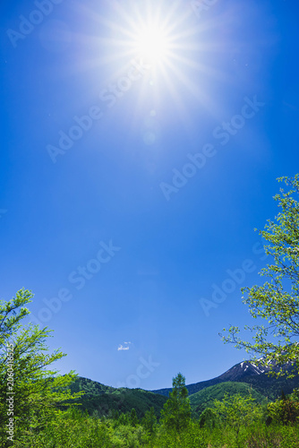Quadro su tela 初夏の青空に輝く強い太陽の光と鮮やかな新緑の山々