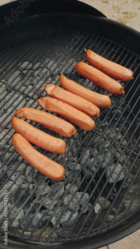 Vertical footage of hot dogs on grill