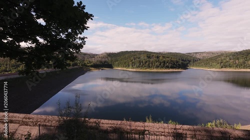 Vast scenic outlook. Serene landscape with lush rolling hills. Expansive natural setting featuring clear water and blue sky