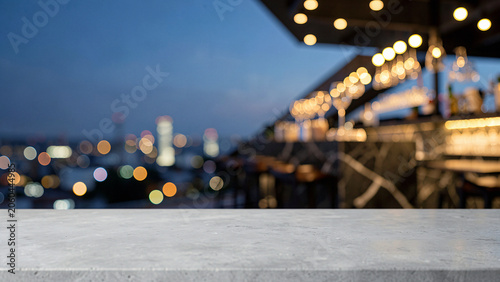 Fotografía Honed Grey Concrete Table Surface on Sophisticated Open Air Rooftop Bar with Bac