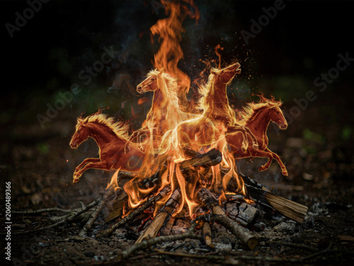 Surreal fire horses galloping from a campfire in the dark forest, concept of wild energy and spiritual motion. Generative AI.