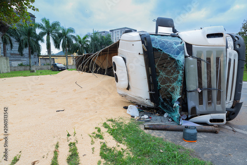 Heavy truck overturned on a city street after a traffic accident. Damaged vehicle blocking the roadway, illustrating transportation risks, road safety, and emergency situations.