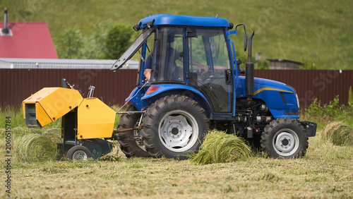 Obraz na plátne A mini hay baler works in cramped conditions, baling small bales
