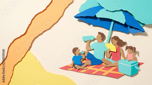 Family enjoying picnic under blue umbrella on sunny beach  