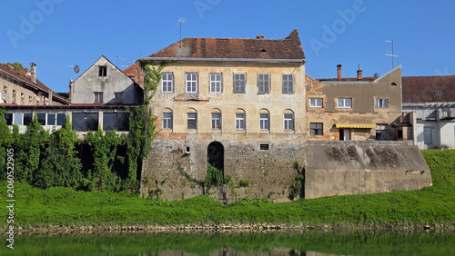 Εκτύπωση καμβά Old historic waterfront palace building with arched windows on a stone bastion w