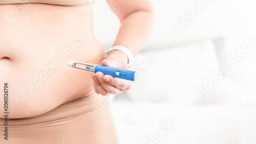 Overweight Woman Holding GLP-1 Injection Pen Before Weight Loss Treatment at Home