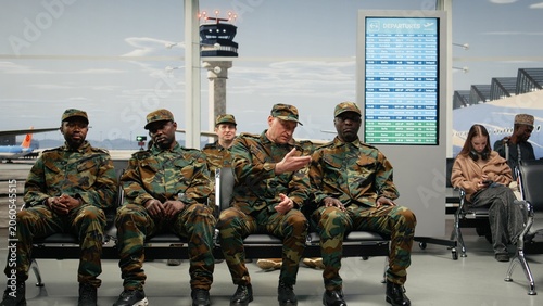 Foto Military veteran in airport commanding army squad to get up from chairs and go to boarding gate with leader and directing with soldier and airplane