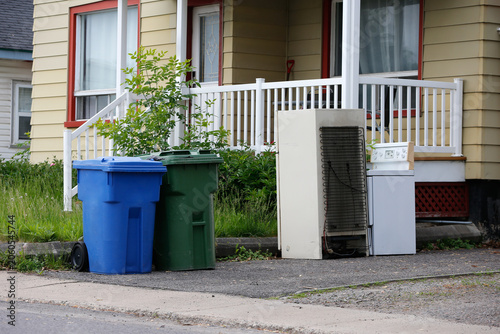 Des poubelles devant une maison à Québec. Un vieux réfrigérateur et une vieille cuisinière dans les ordures.