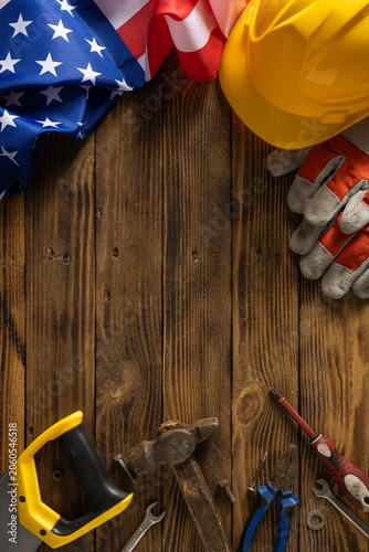 Fotografía Labor Day USA flag and construction tools on vertical wooden background honoring