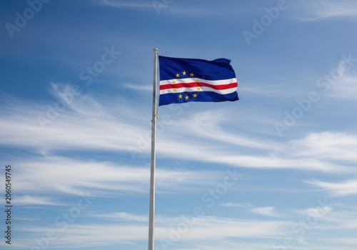 Flag of cape verde waving against a bright blue sky with wispy clouds