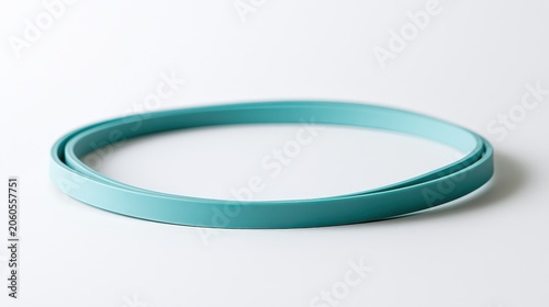 Turquoise rubber band resting on white surface for simple office tasks and organization needs