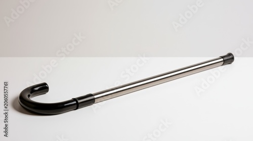 Walking cane lies on a flat surface in a simple setting during the day