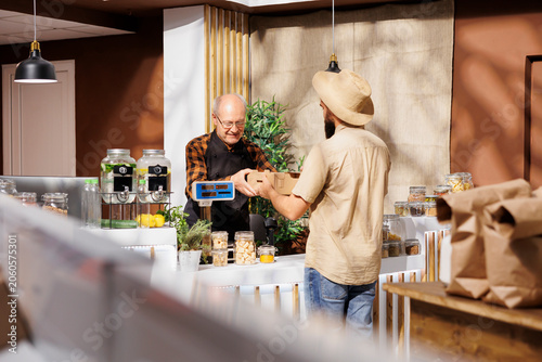 Photography Farmer providing freshly harvested vegetables to merchant selling it to environmentally conscious customers in zero waste shop
