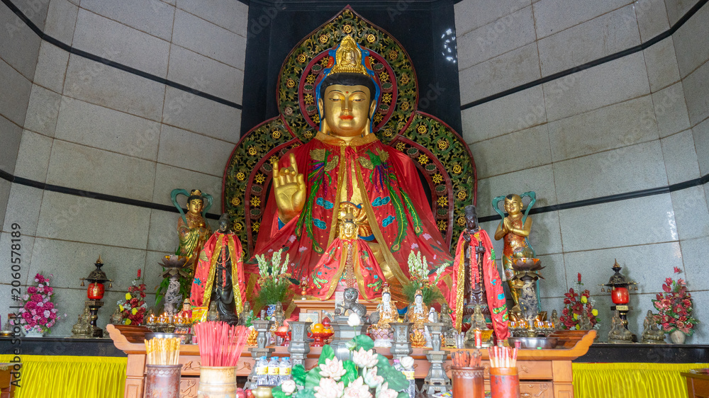 Fototapeta premium Golden Guan Yin Bodhisattva Statue with Red Robe inside Buddhist Temple