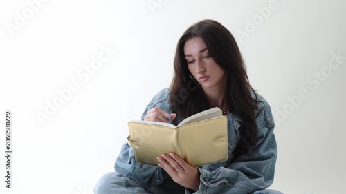 Creative writing and journaling concept with a young woman writing in a notebook with a pen. Isolated on a clean white background, educational content, study materials, and personal development. The w