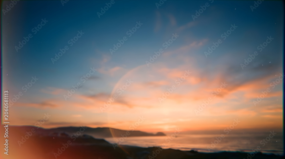 Fototapeta premium Abstract blurred sunset over the sea with distant mountains and orange sky