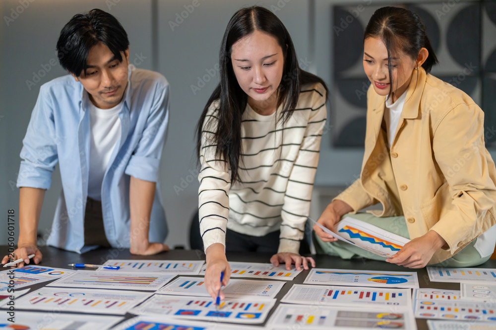 Fototapeta premium Market research, Asian business team analyzing data charts on table, consumer insight, data analysis, marketing strategy, teamwork, problem solving, business development and corporate collaboration