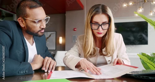Business professionals reviewing documents at modern office table
