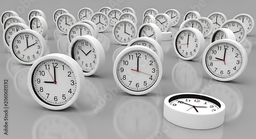 Multiple white alarm clocks arranged on a reflective surface showing various times