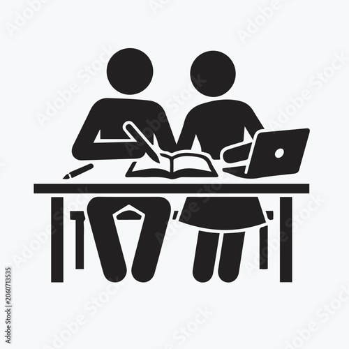 two people sitting at desk with laptop and book