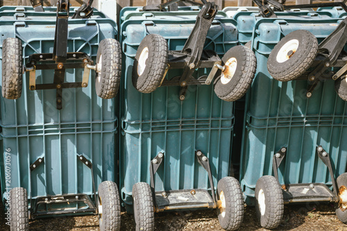 Stack of folded utility carts parked outside a flower shop or garden center, ready for transporting plants and gardening supplies. The image highlights retail operations, and horticulture businesses