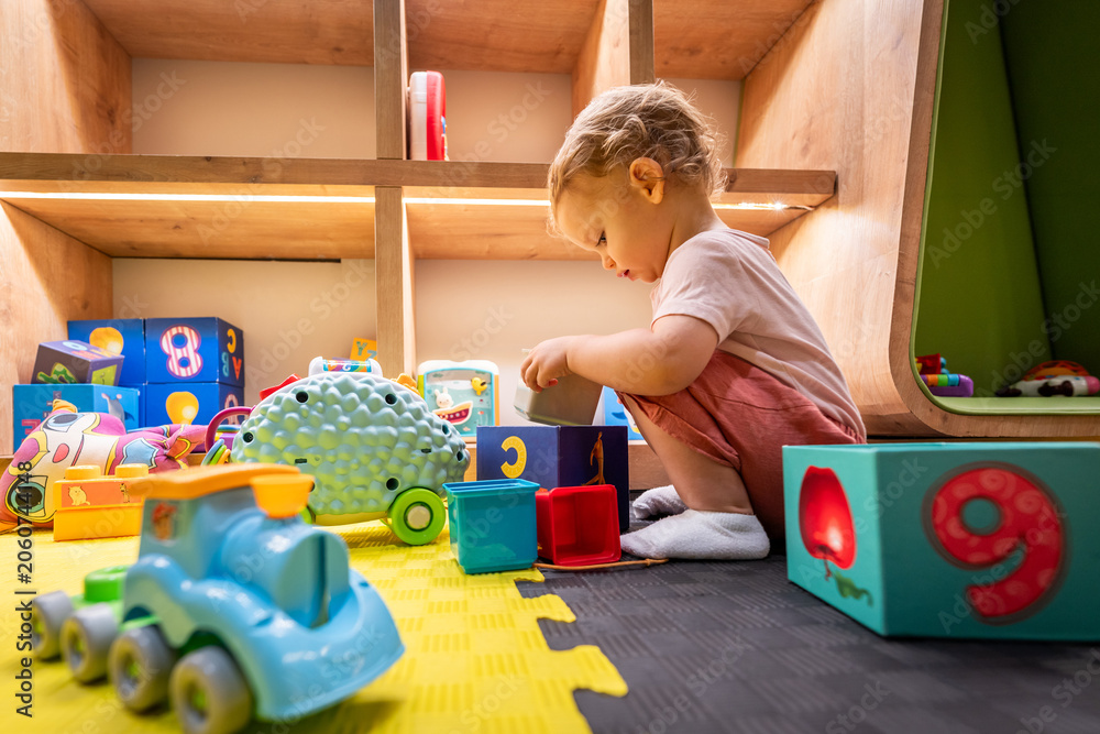 Fototapeta premium Child discovering colorful blocks and playful toys in a bright and inviting play space