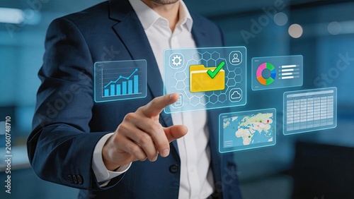 Businessman interacting with futuristic holographic interface, touching virtual folder icon, data analytics charts, global map, and spreadsheet grids. Modern technology concept,